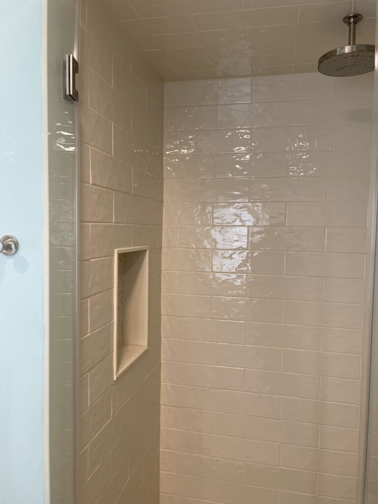 A clean, tiled shower stall with a built-in niche and a beige color scheme.
