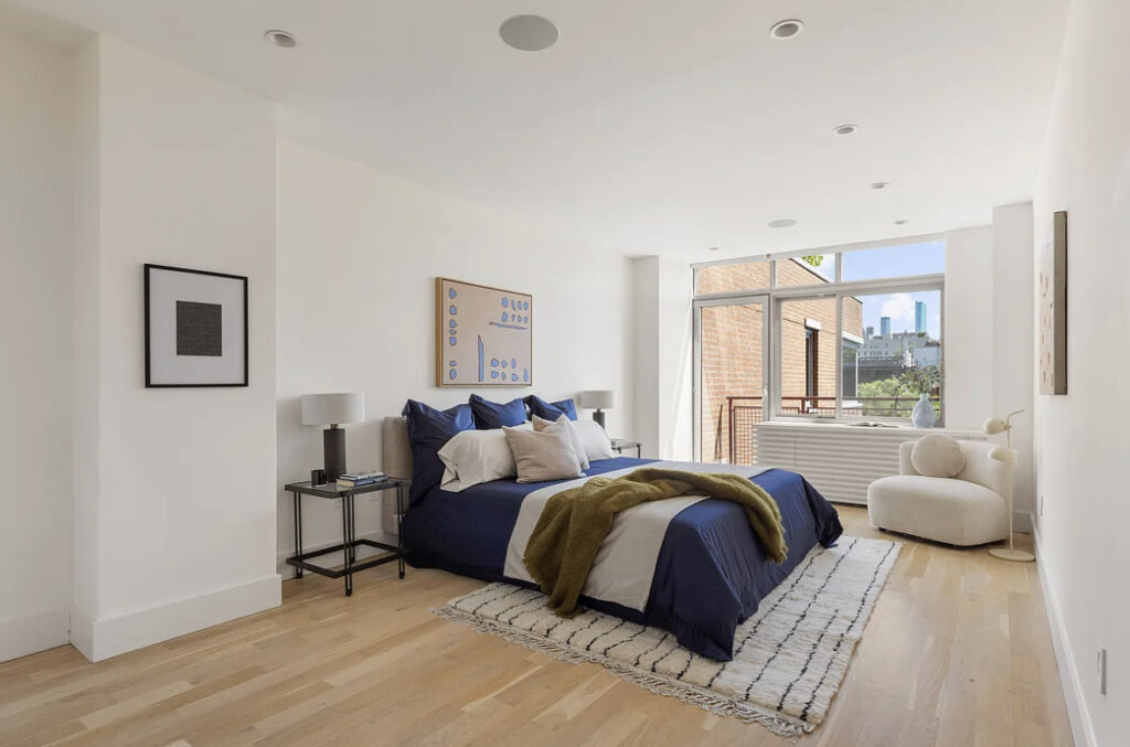 Modern bedroom with natural light, navy bedding, and minimalist decor.
